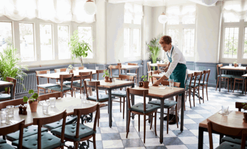 A waiter is organizing the dining area