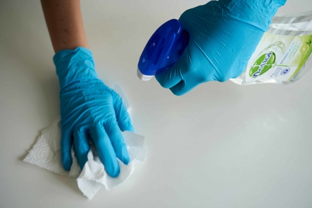 Hands using cleaning materials on a table